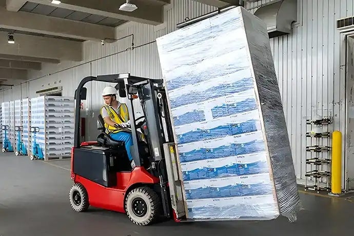 Products being transported for shipment. Sheet pallets are used to improve loading efficiency.